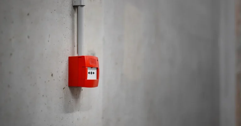 Serwisant systemów pożarowych oczyszcza komorę pomiarową czujki dymu na suficie